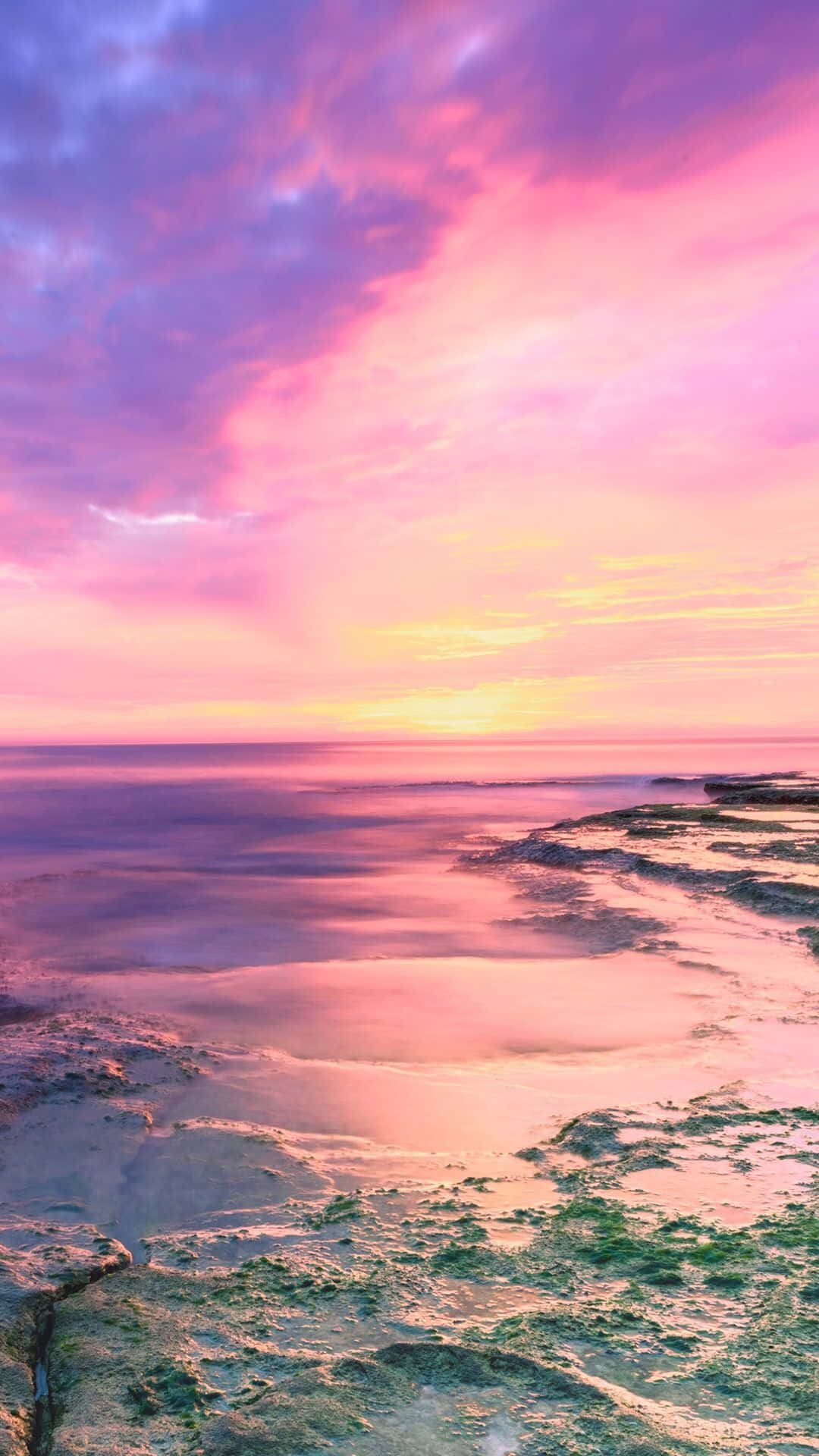 A Pink And Purple Sunset Over The Ocean Background