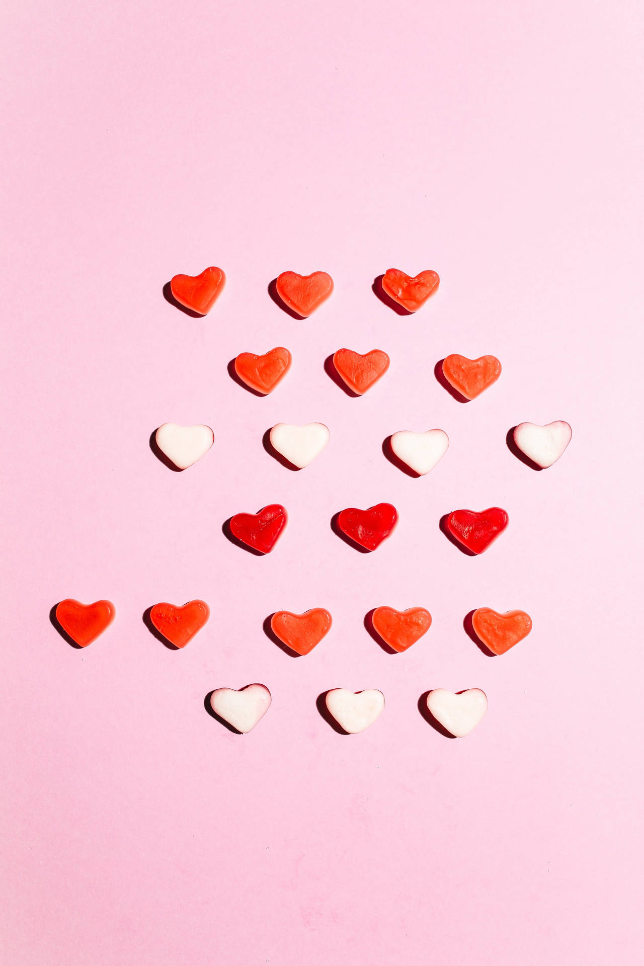 A Pink Background With Red And White Hearts Background