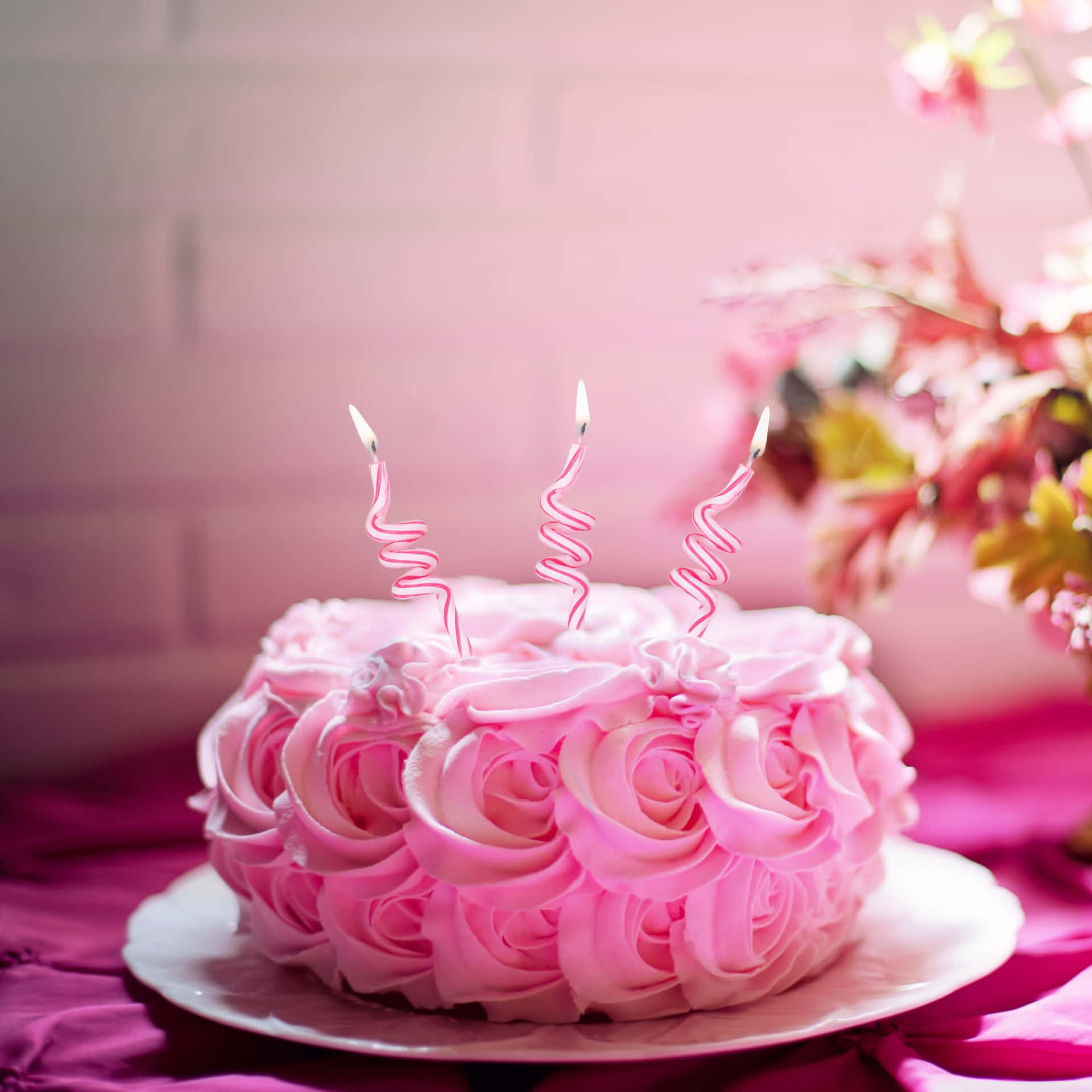 A Pink Cake With Candles On Top Background