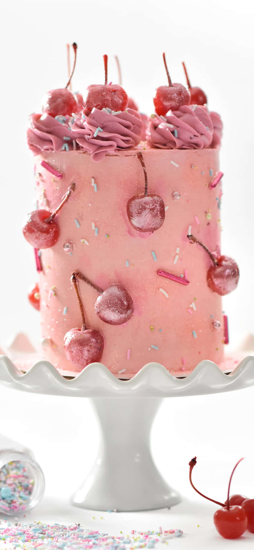 A Pink Cake With Cherries On Top Background