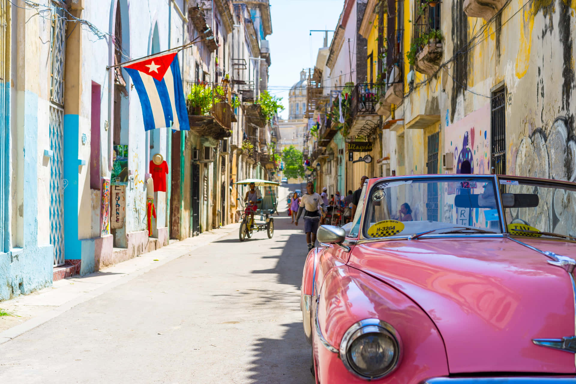 A Pink Car Parked On A Narrow Street Background