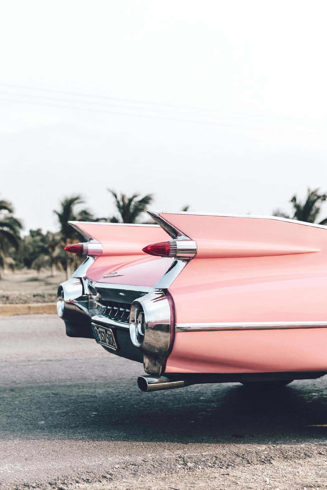 A Pink Car Parked On The Side Of The Road Background