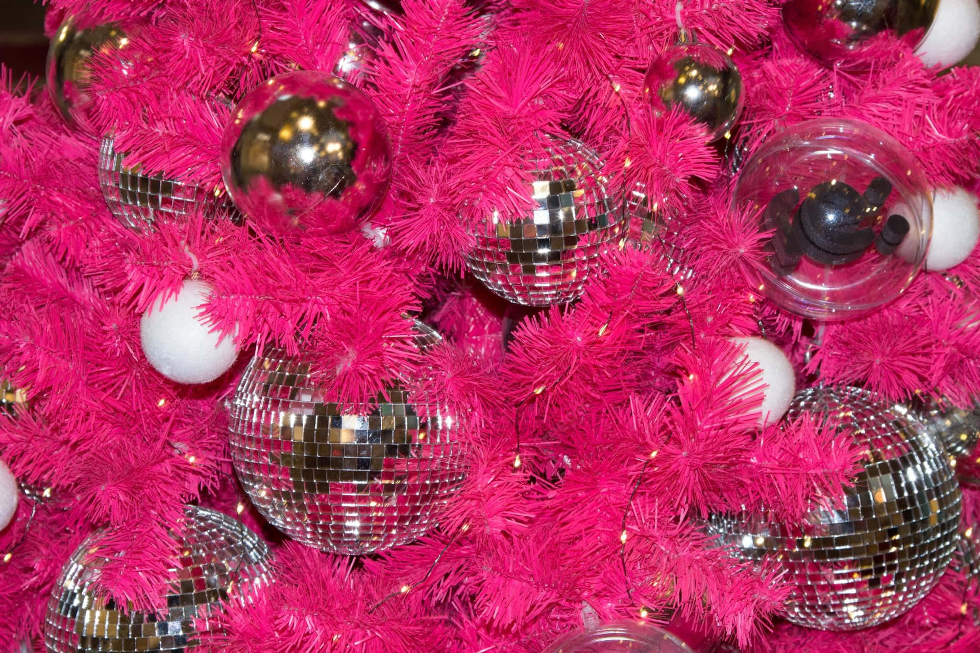 A Pink Christmas Tree With Disco Balls And Silver Ornaments Background