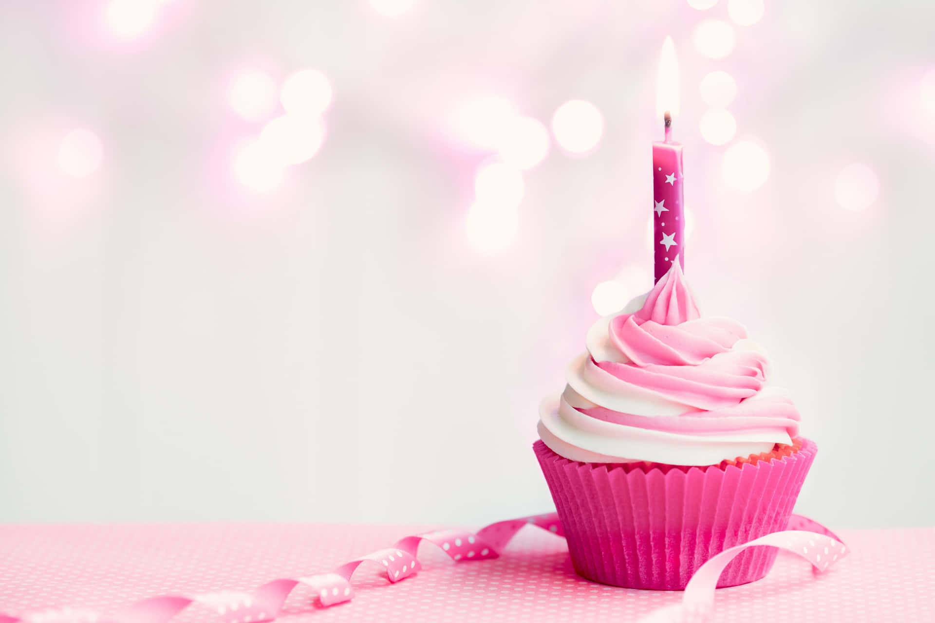 A Pink Cupcake With A Candle On Top Background