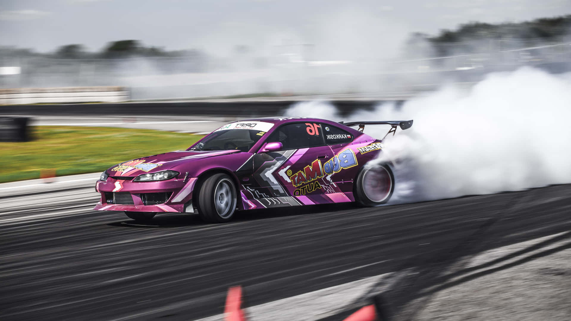 A Pink Drift Car Is Driving Down A Track