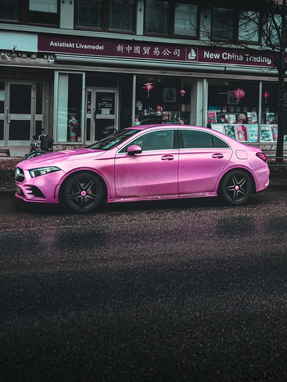 A Pink Mercedes Cla Parked In Front Of A Building Background