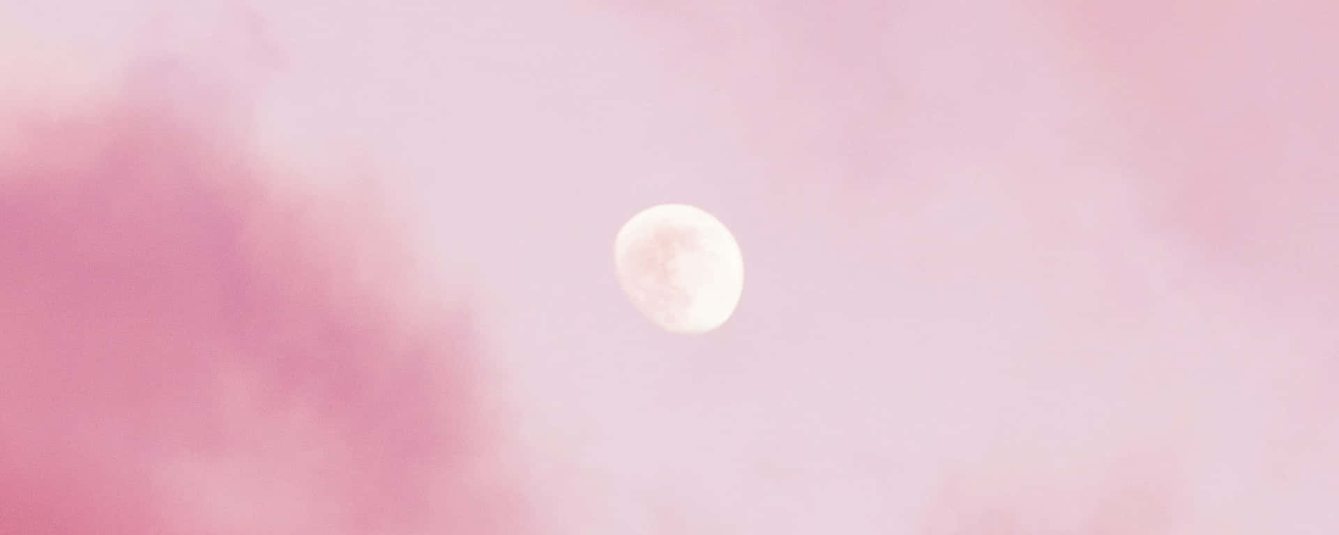 A Pink Moon In The Sky With Clouds Background