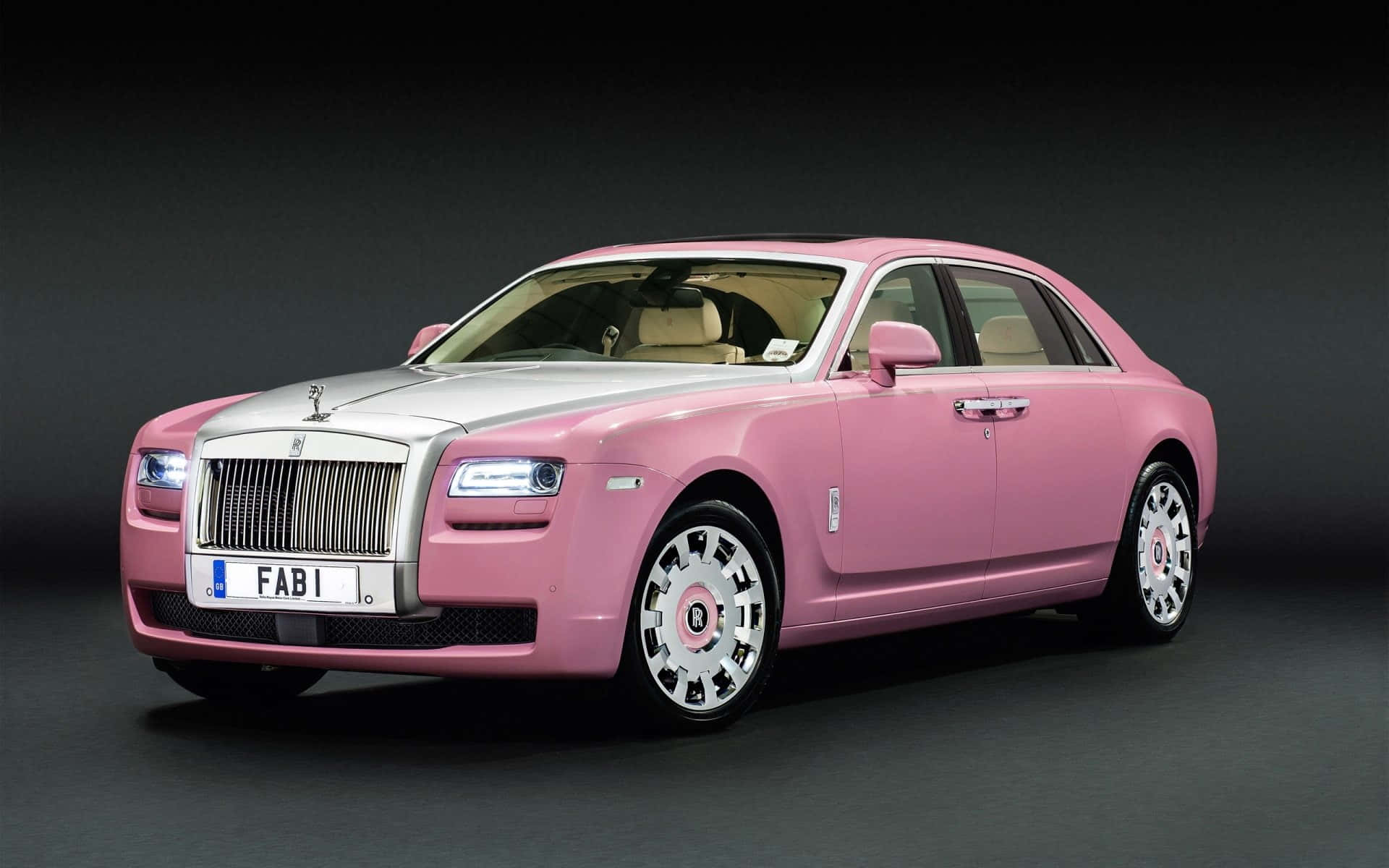 A Pink Rolls Royce Is Shown In A Dark Room Background