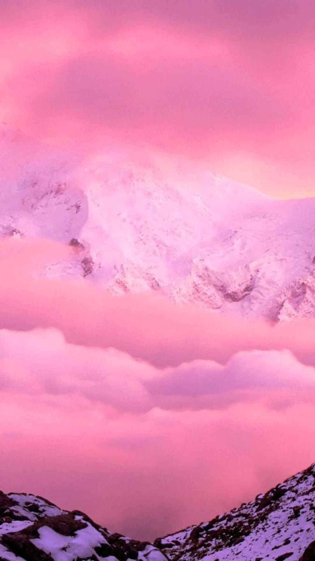 A Pink Sky With Clouds Over A Snow Covered Mountain