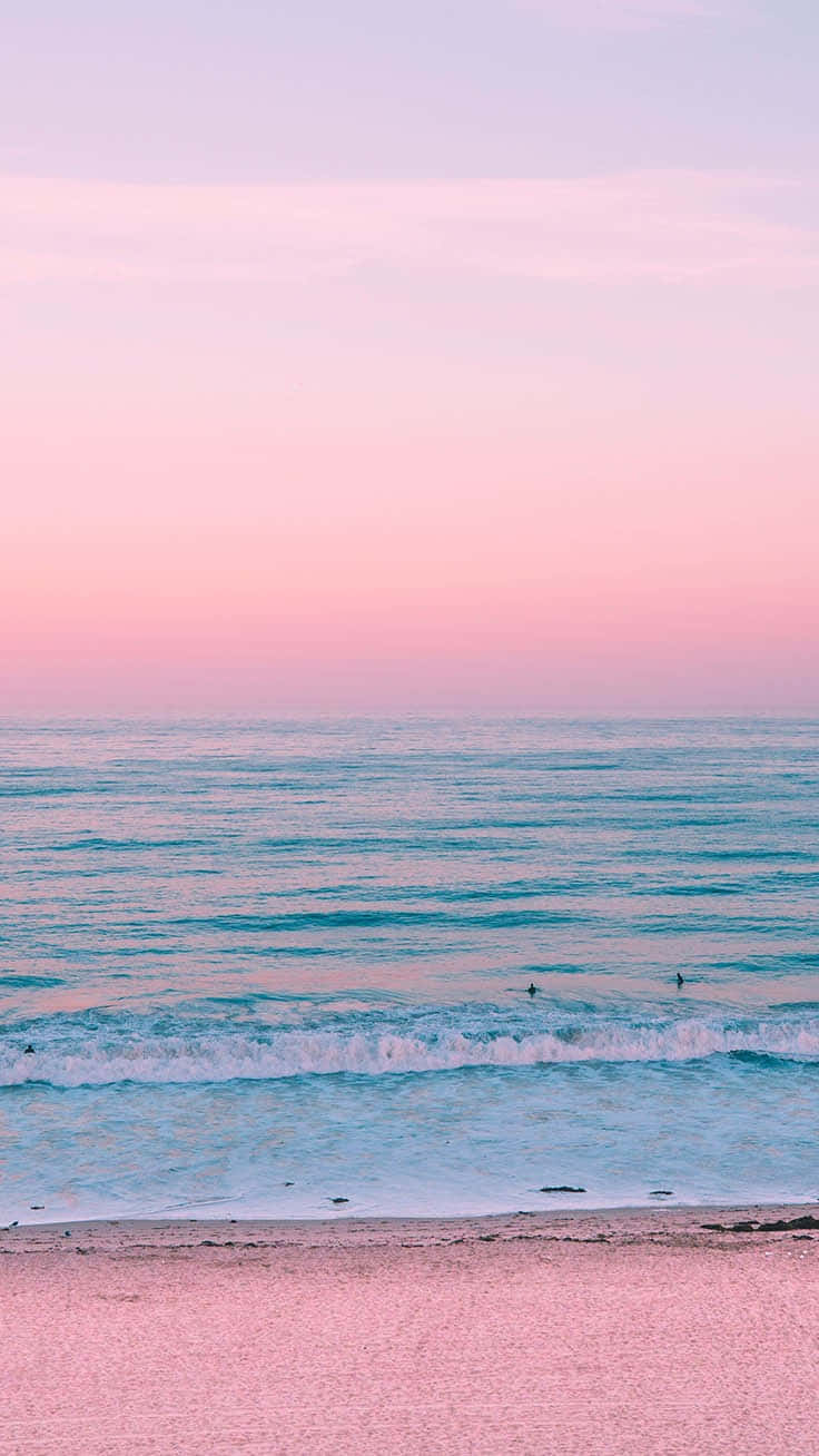 A Pink Sunset On The Beach With A Surfboard Background