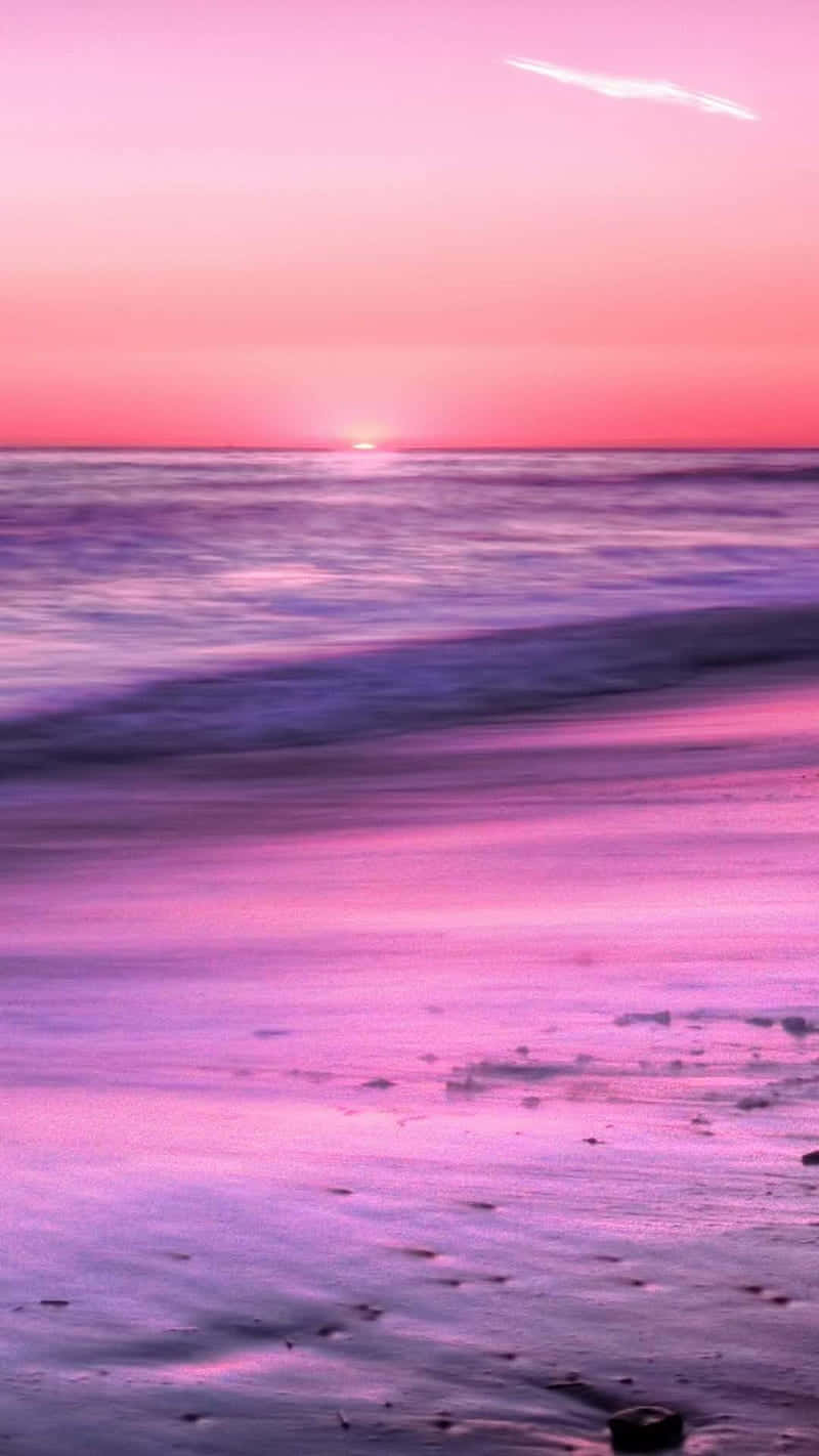 A Pink Sunset On The Beach With Waves Background