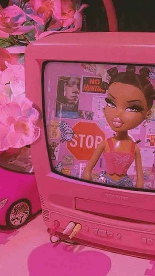 A Pink Television With A Doll Sitting On Top Background