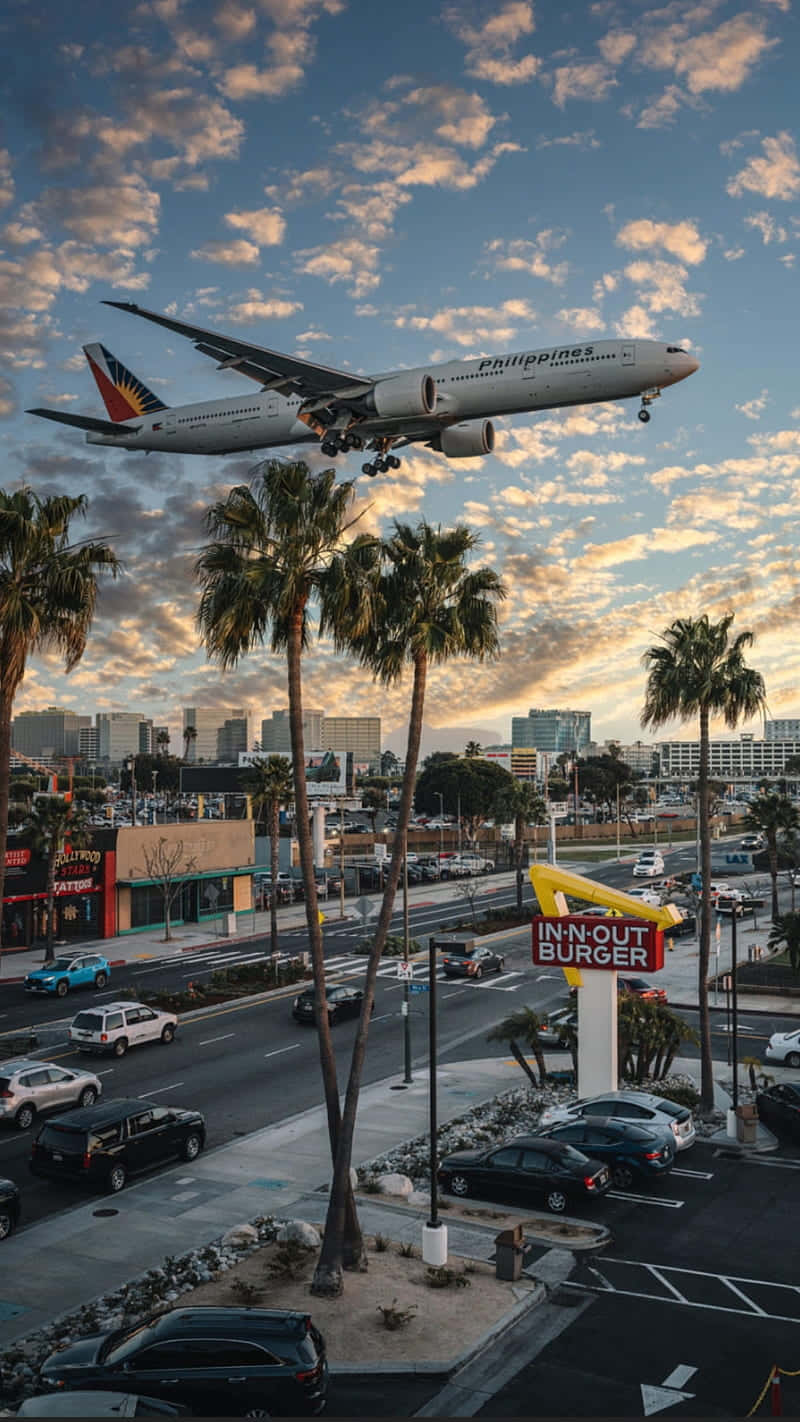 A Plane Flying Over A City Background