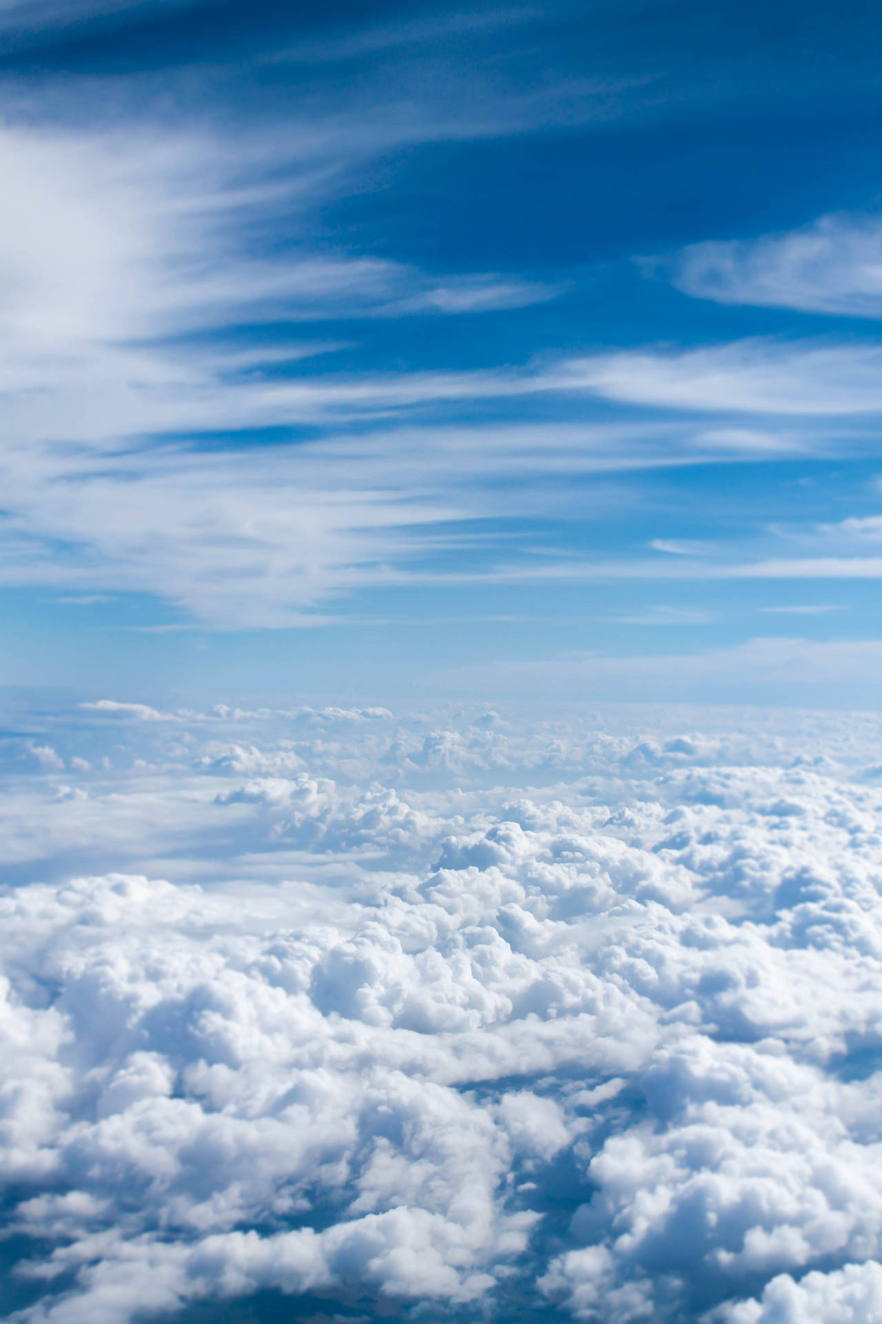 A Plane Flying Over The Clouds Background