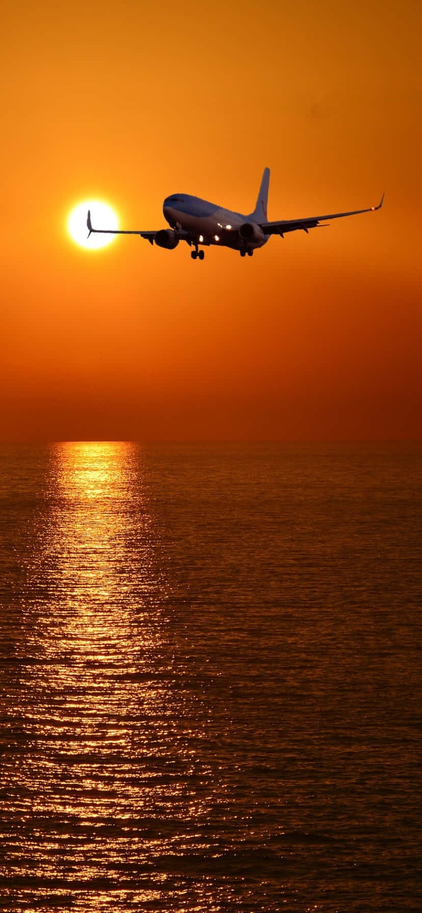 A Plane Flying Over The Ocean Background