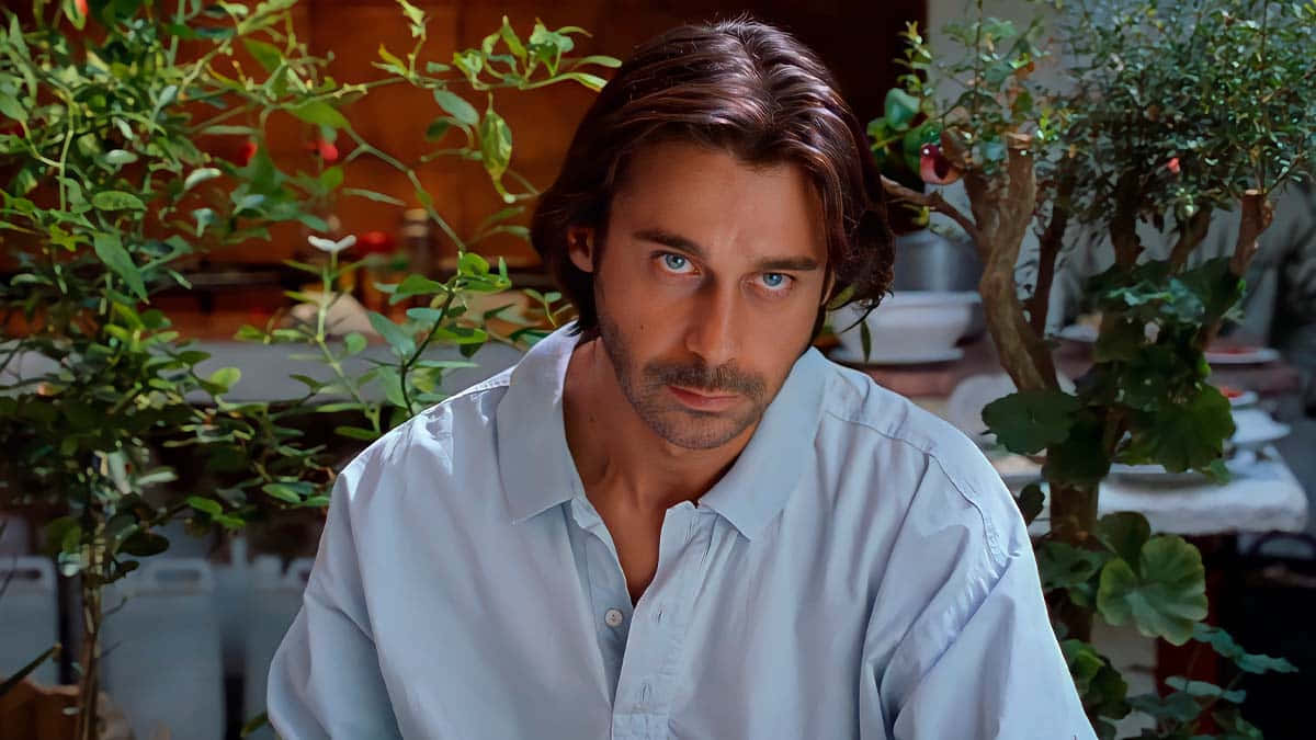 A Poised Jordi Mollà Radiating Intensity On The Big Screen Background