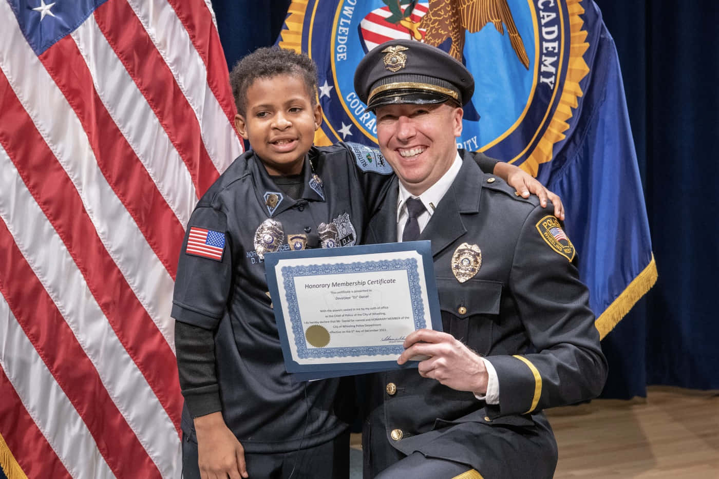 A Police Officer Presents A Certificate To A Young Boy Background
