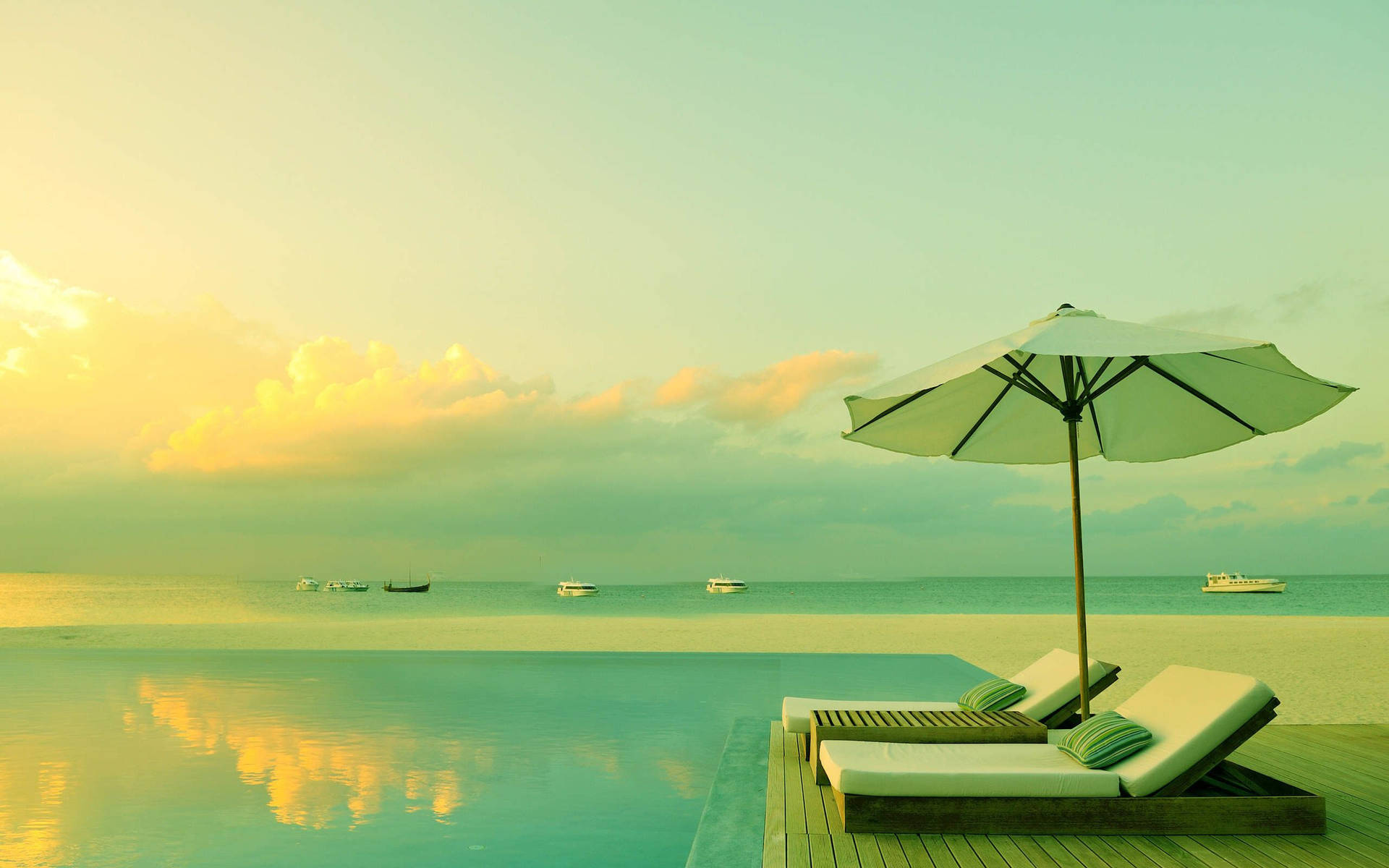 A Pool With Lounge Chairs And An Umbrella