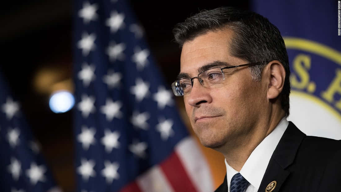 A Portrait Of Xavier Becerra In His Office Background