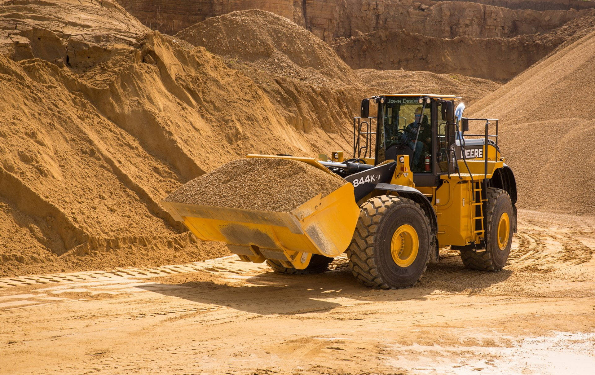 A Powerful John Deere Wheel Loader In Action At The Construction Site. Background