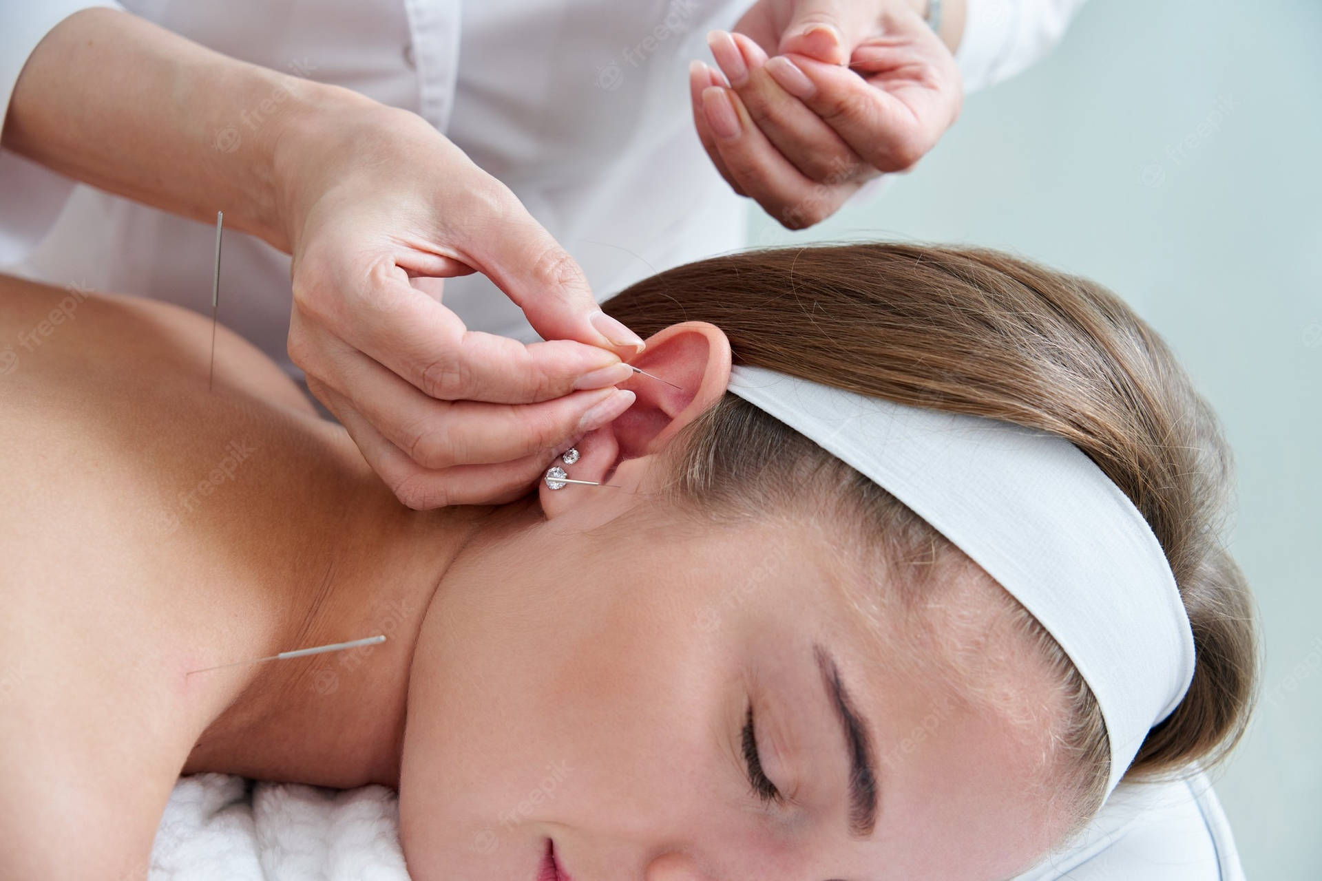 A Professional Acupuncturist Administering Ear Needle Treatment Background