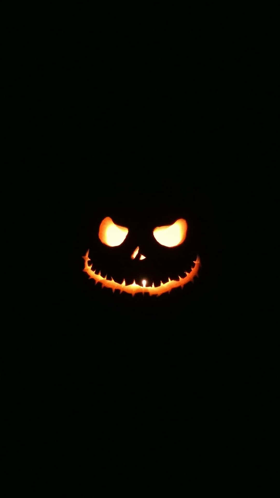 A Pumpkin With A Scary Face In The Dark