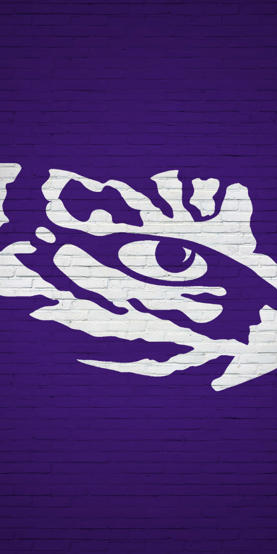 A Purple And White Tiger Logo On A Brick Wall