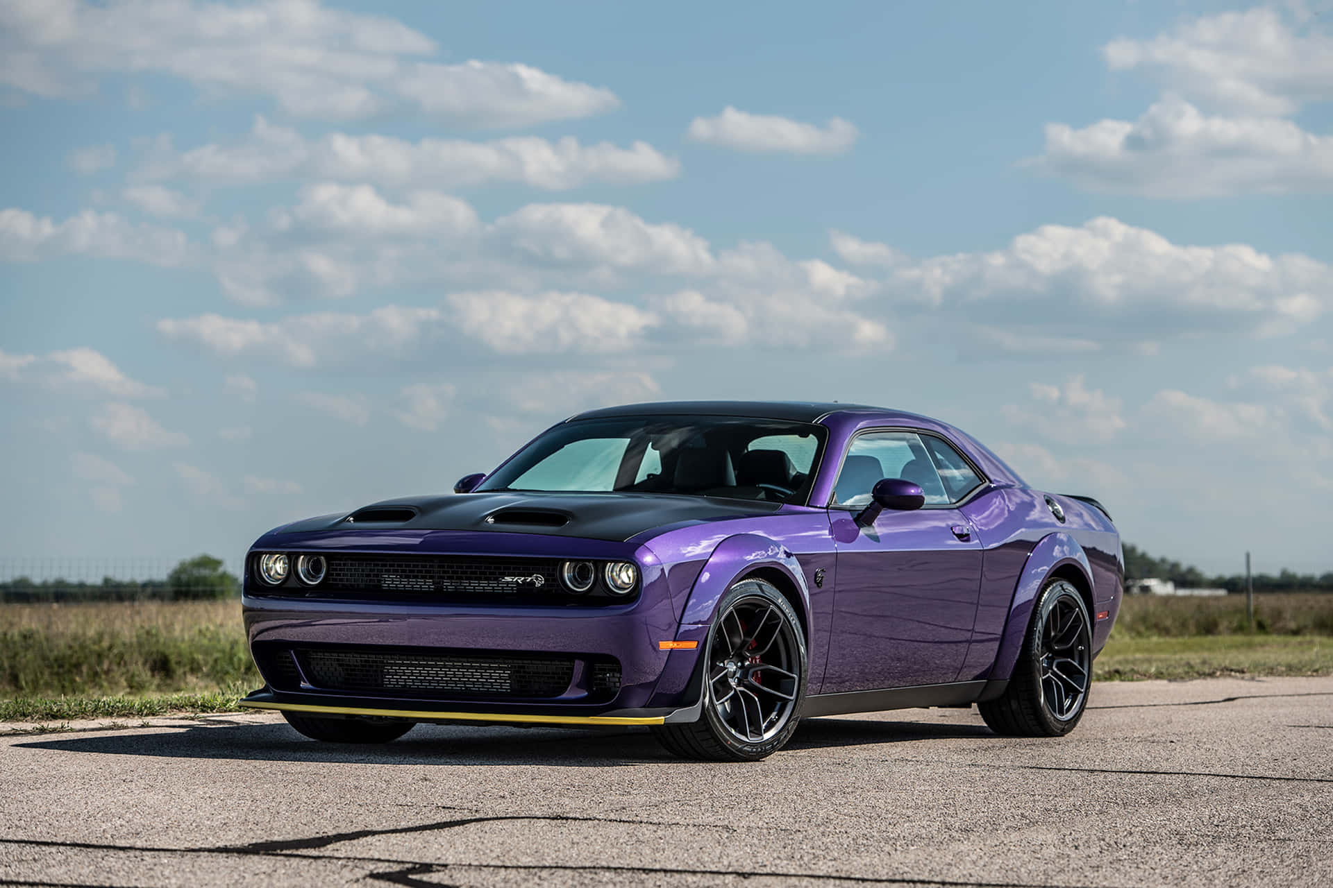 A Purple Dodge Challenger Srt Parked On A Road Background