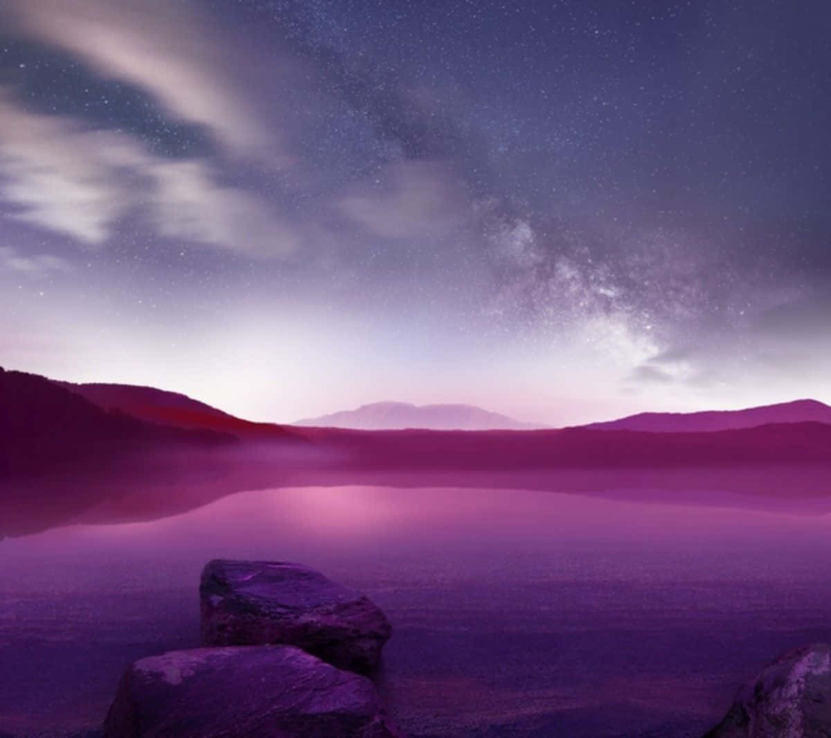 A Purple Sky With Rocks And A Lake Background