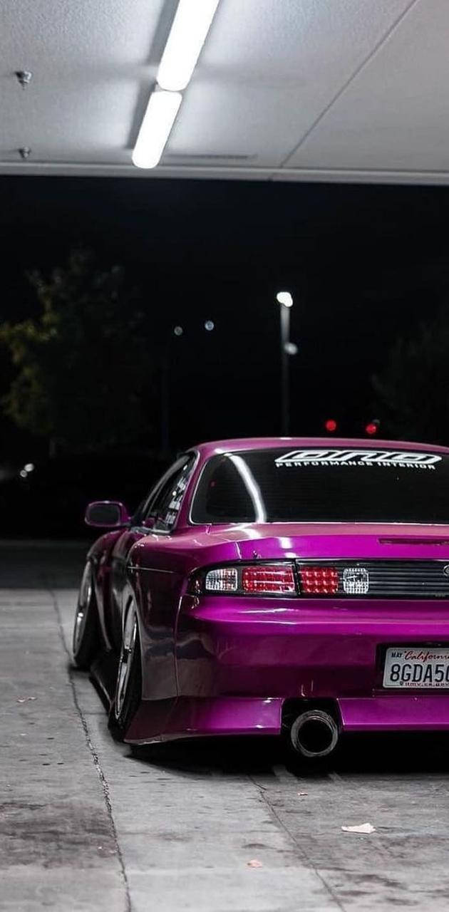 A Purple Sports Car Parked In A Garage At Night Background