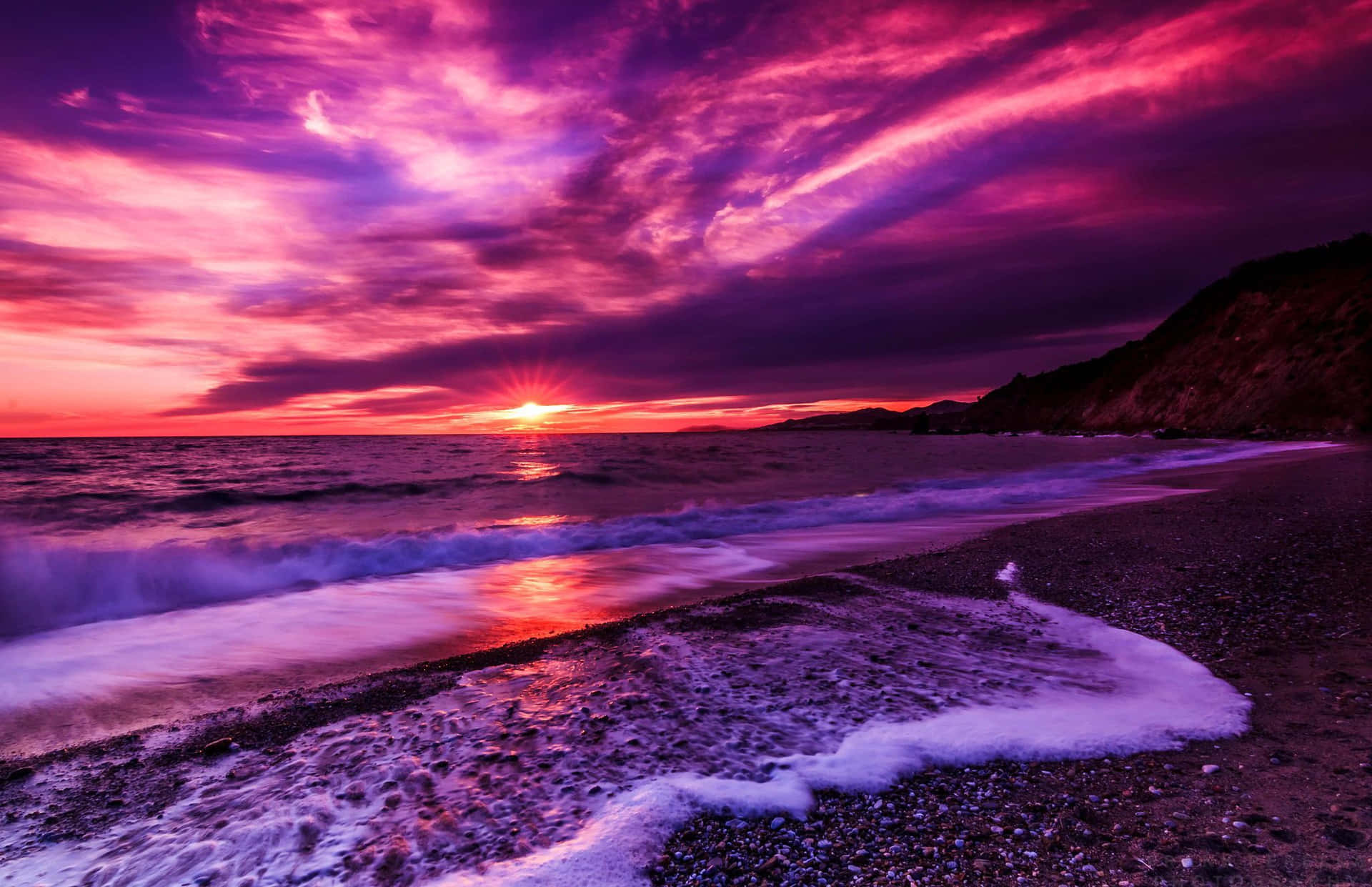 A Purple Sunset Over The Ocean With Waves Background