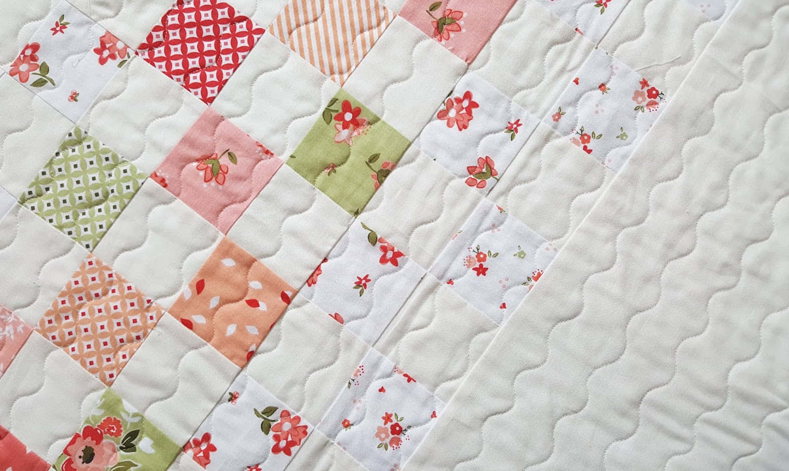 A Quilt With A Patchwork Pattern And Flowers Background