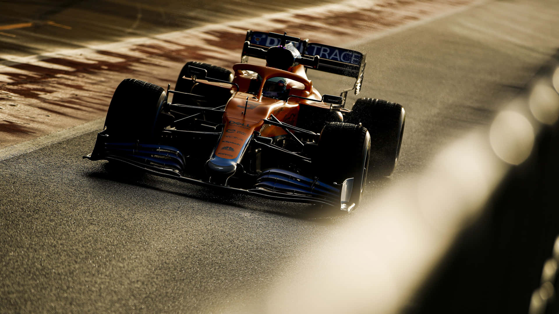 A Racing Car Driving Down A Track Background