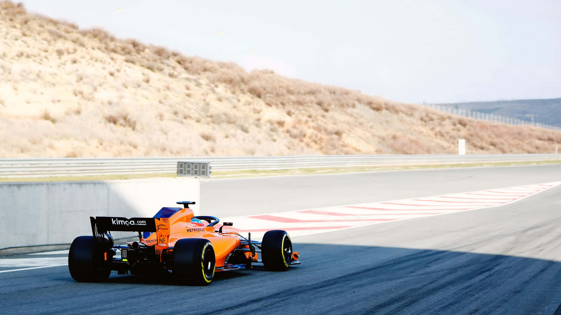 A Racing Car Driving Down A Track Background