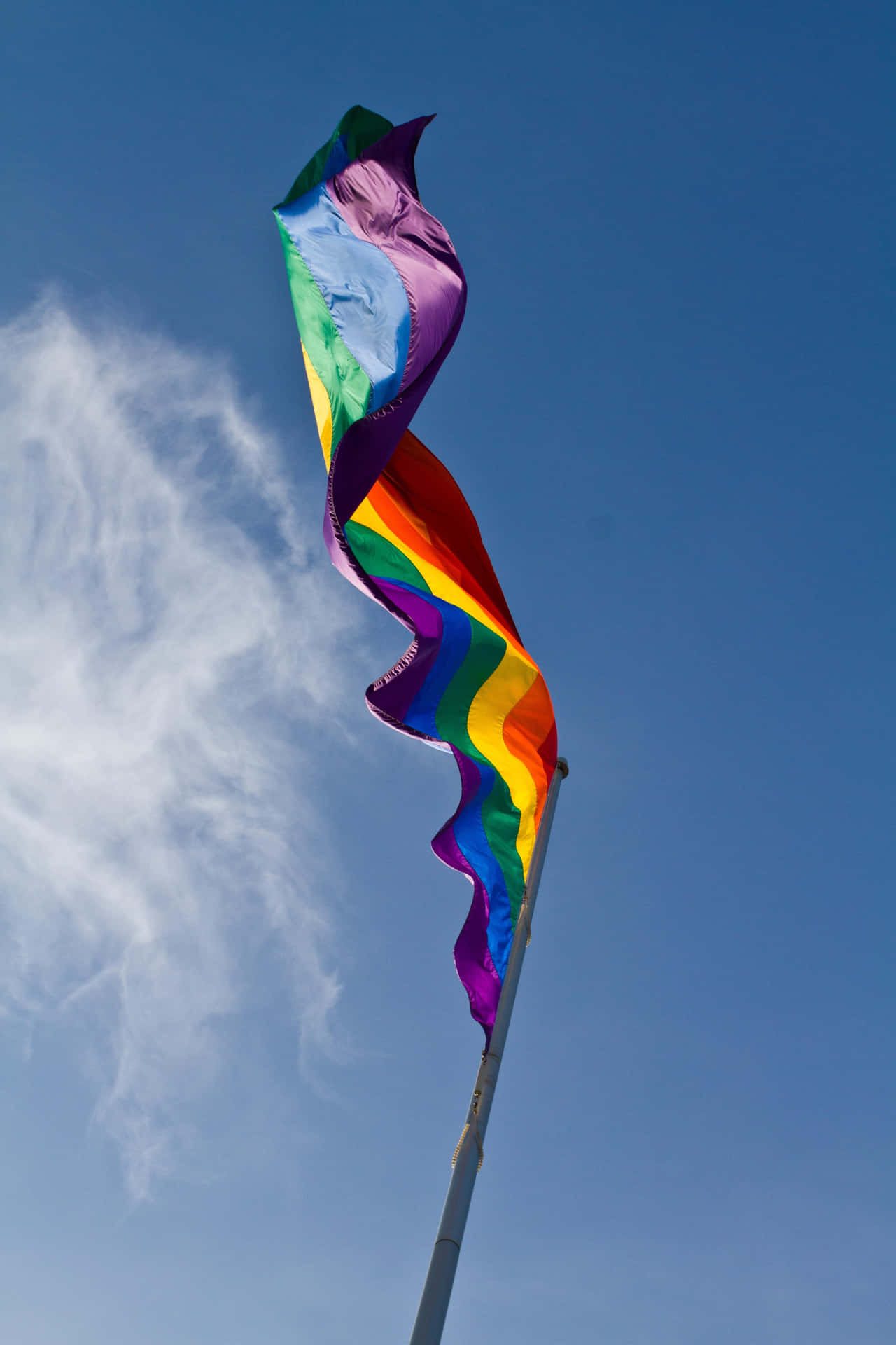 A Rainbow Flag Flying In The Wind