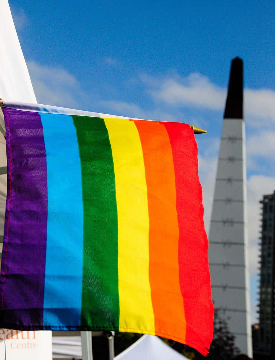 A Rainbow Flag Hanging From A Building Background