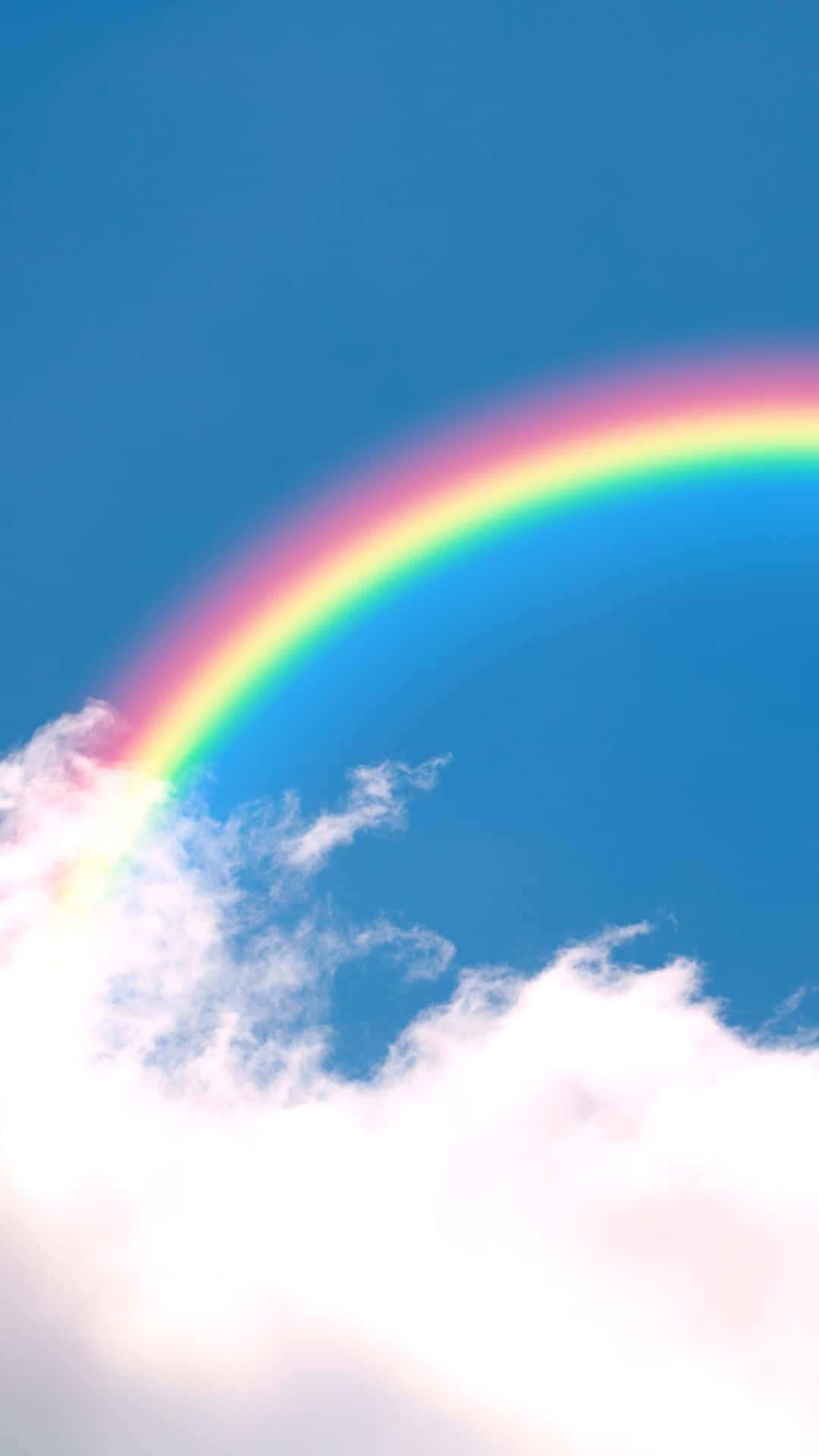 A Rainbow Is Seen In The Sky Above A Cloud Background