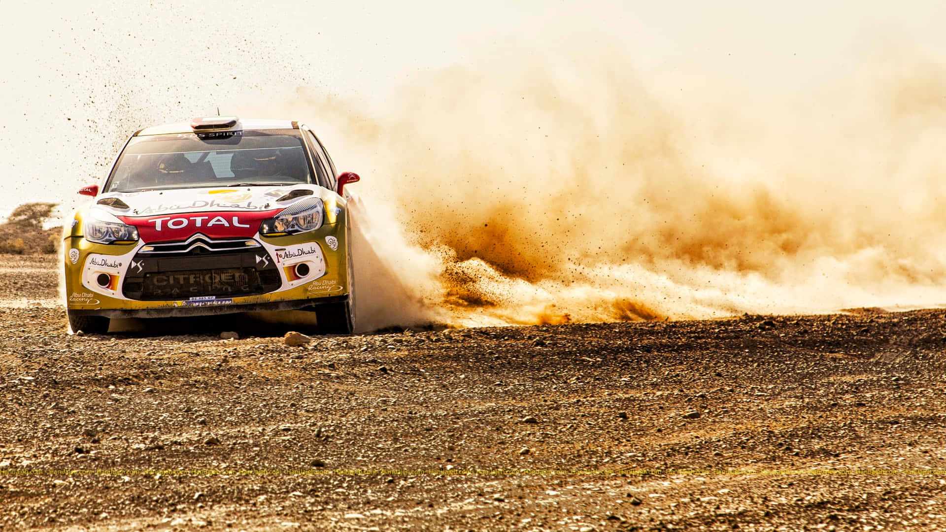 A Rally Car Driving Through A Dusty Area Background