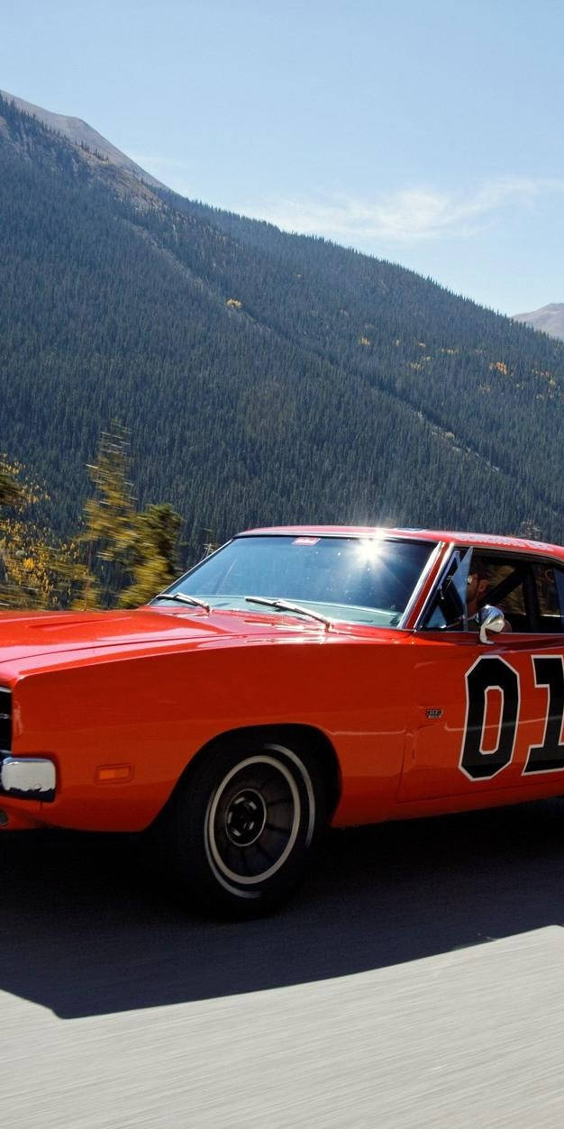 A Red And Orange Car Driving Down A Road