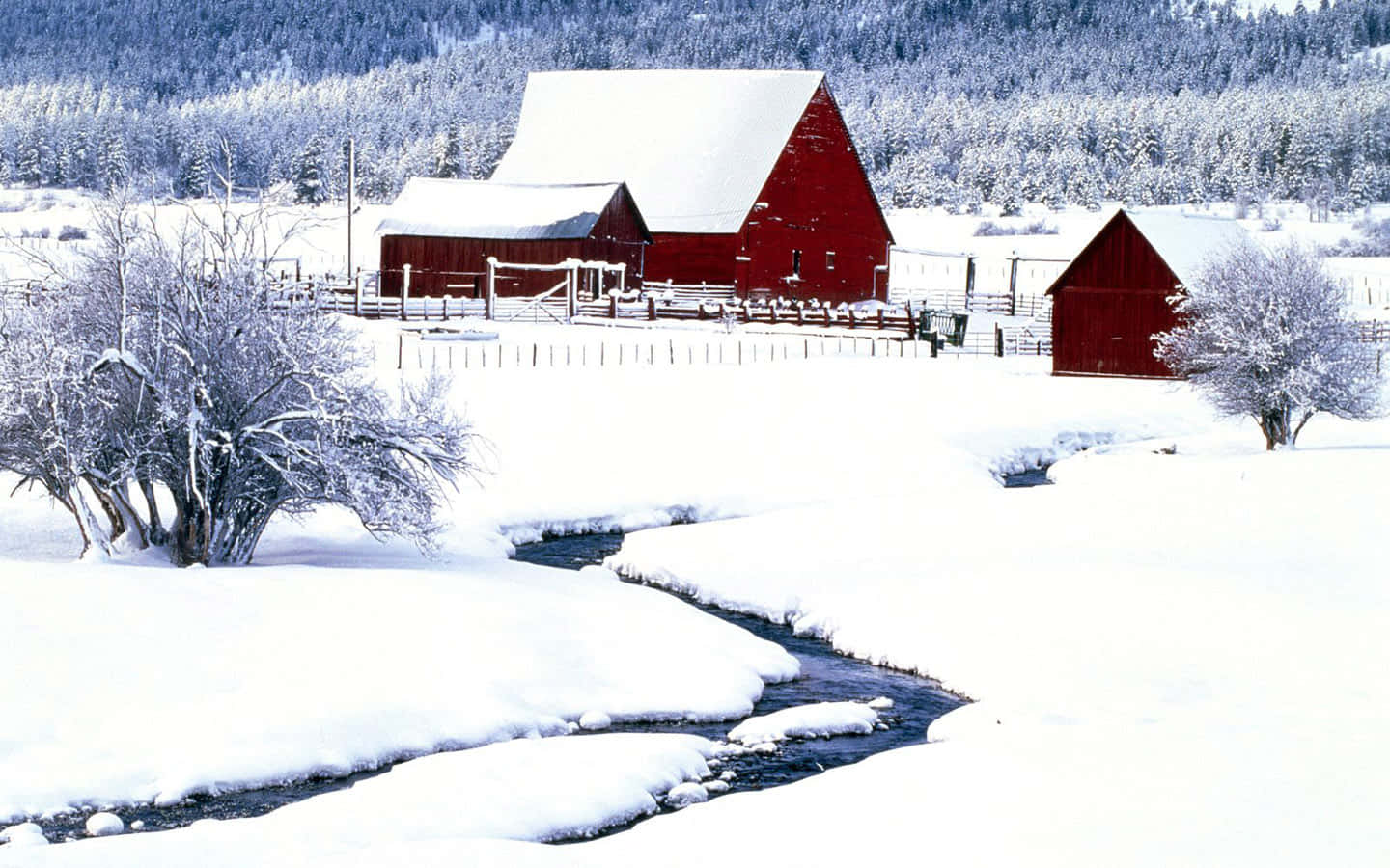 A Red Barn In The Snow With A Stream Background