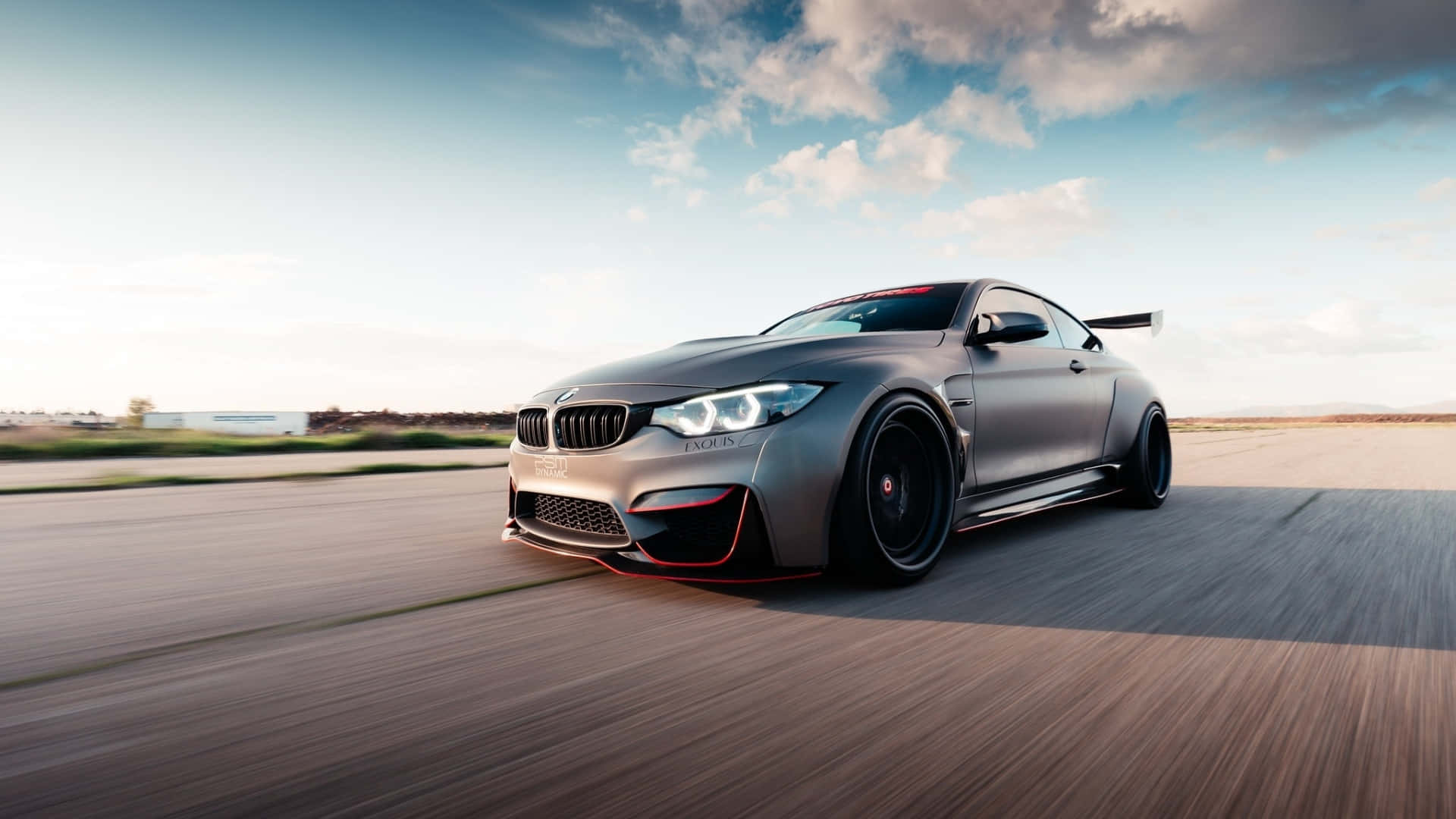 A Red Bmw Sports Car Parked In Front Of A City Skyline Background