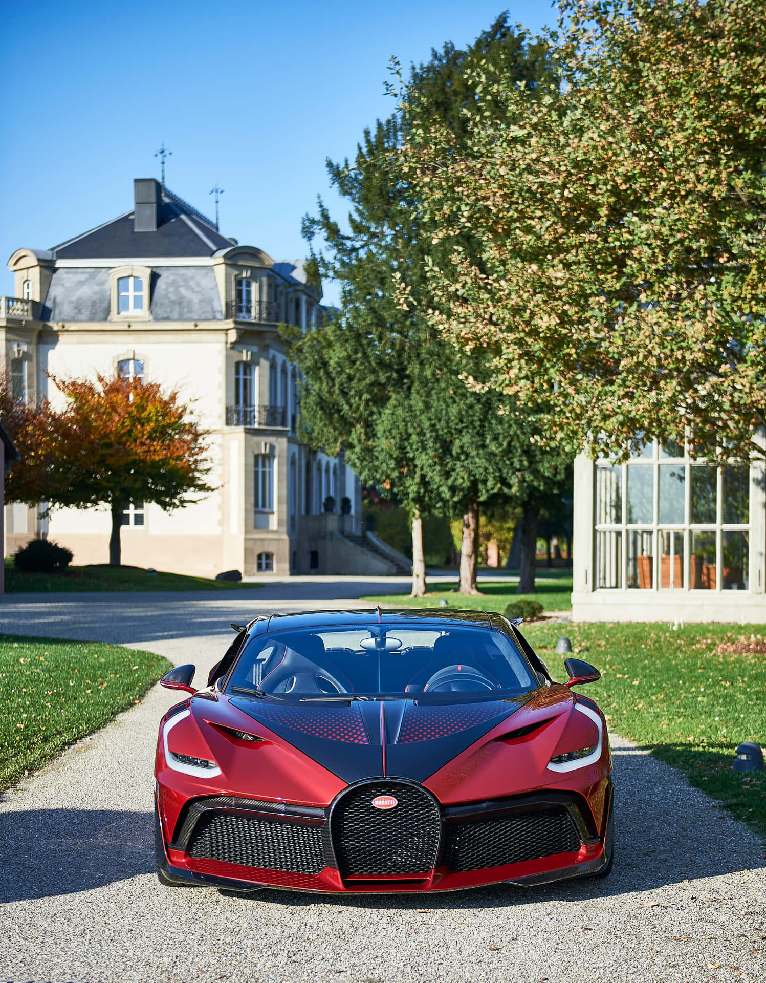 A Red Bugatti Parked In Front Of A House Background