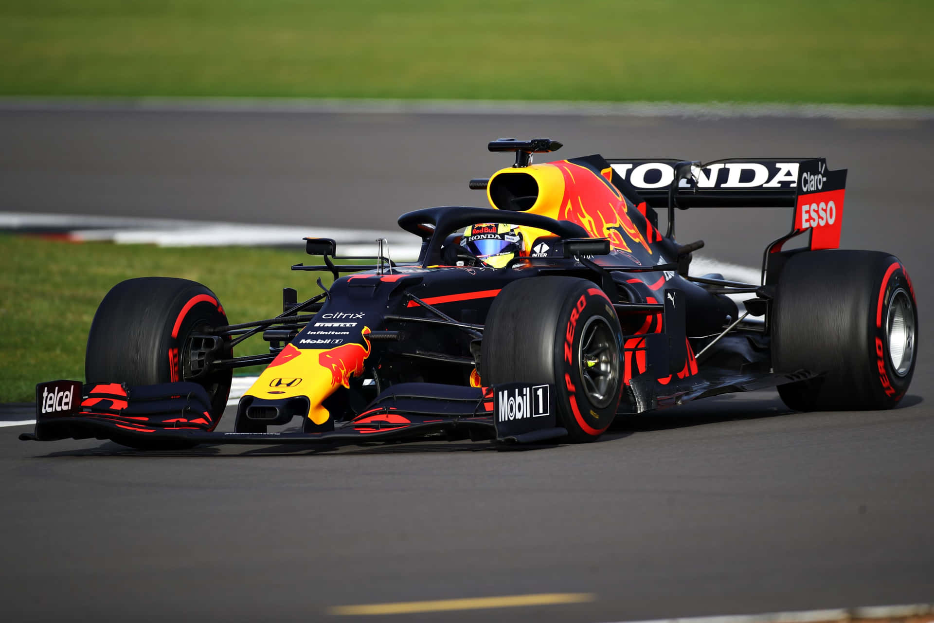 A Red Bull Racing Car Is Driving On A Track Background