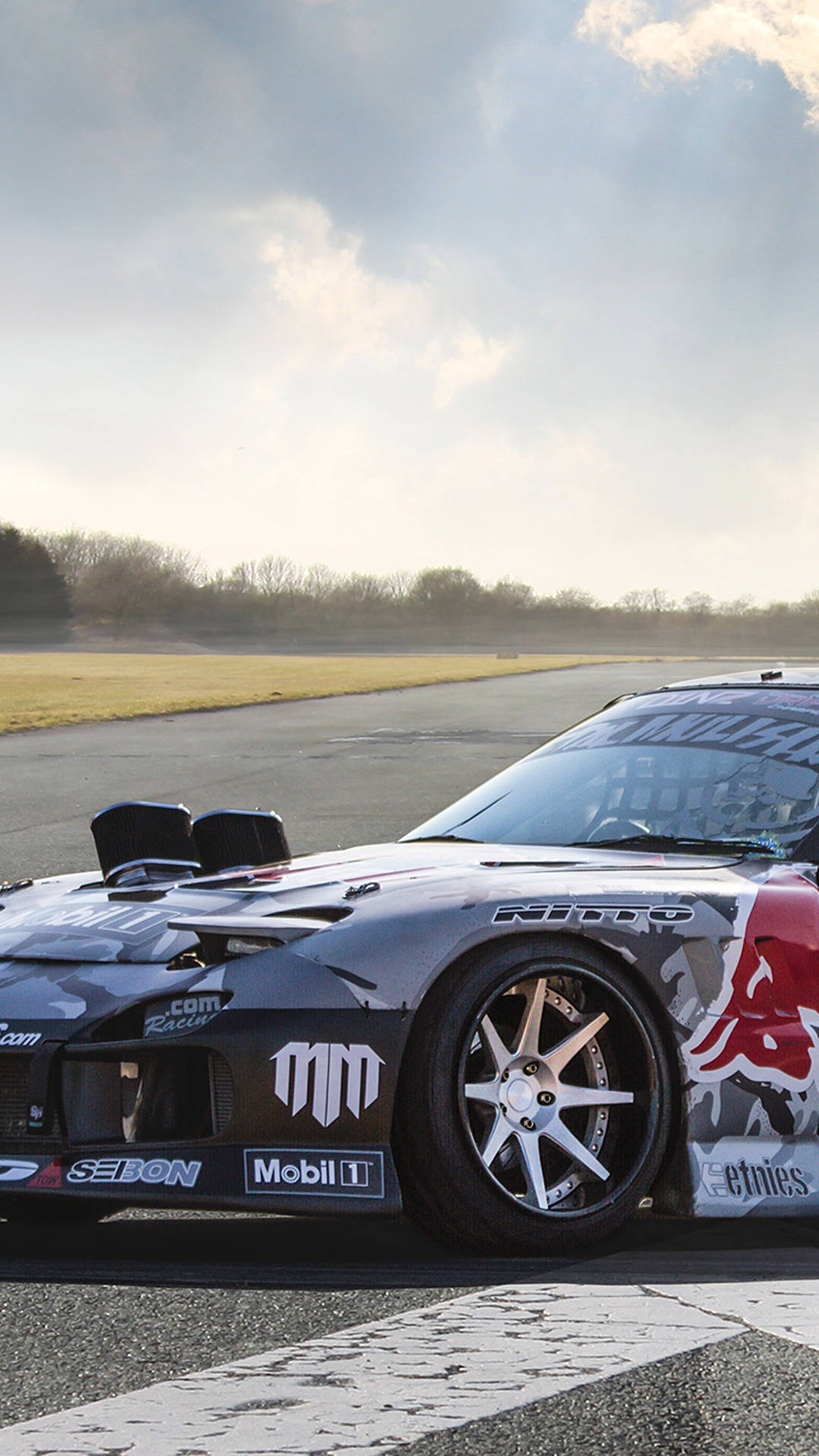 A Red Bull Racing Car On A Track Background