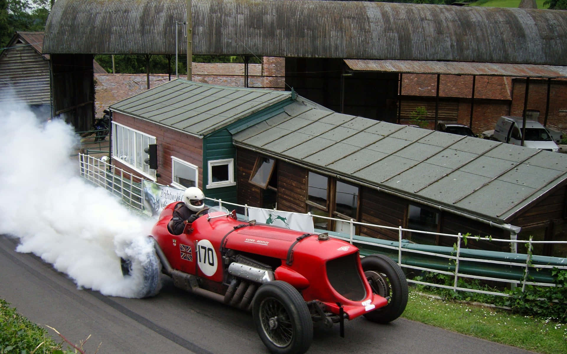 A Red Car Driving Down A Road Background