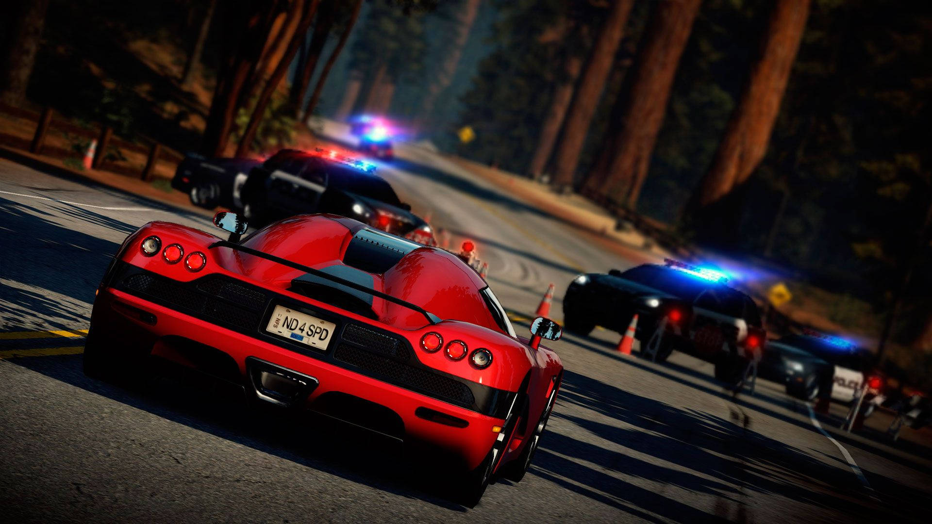 A Red Car Driving Down A Road With Police Cars Background