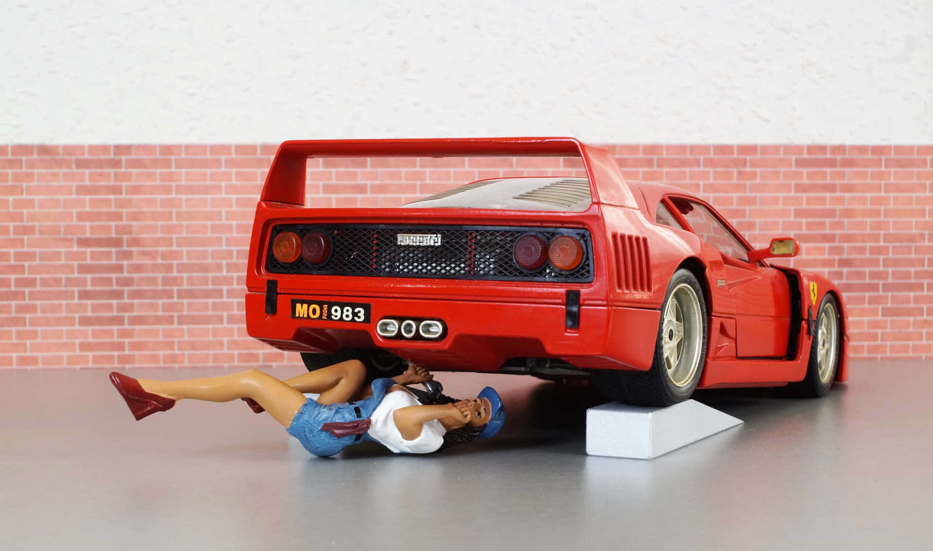 A Red Car Is On A Brick Wall Background