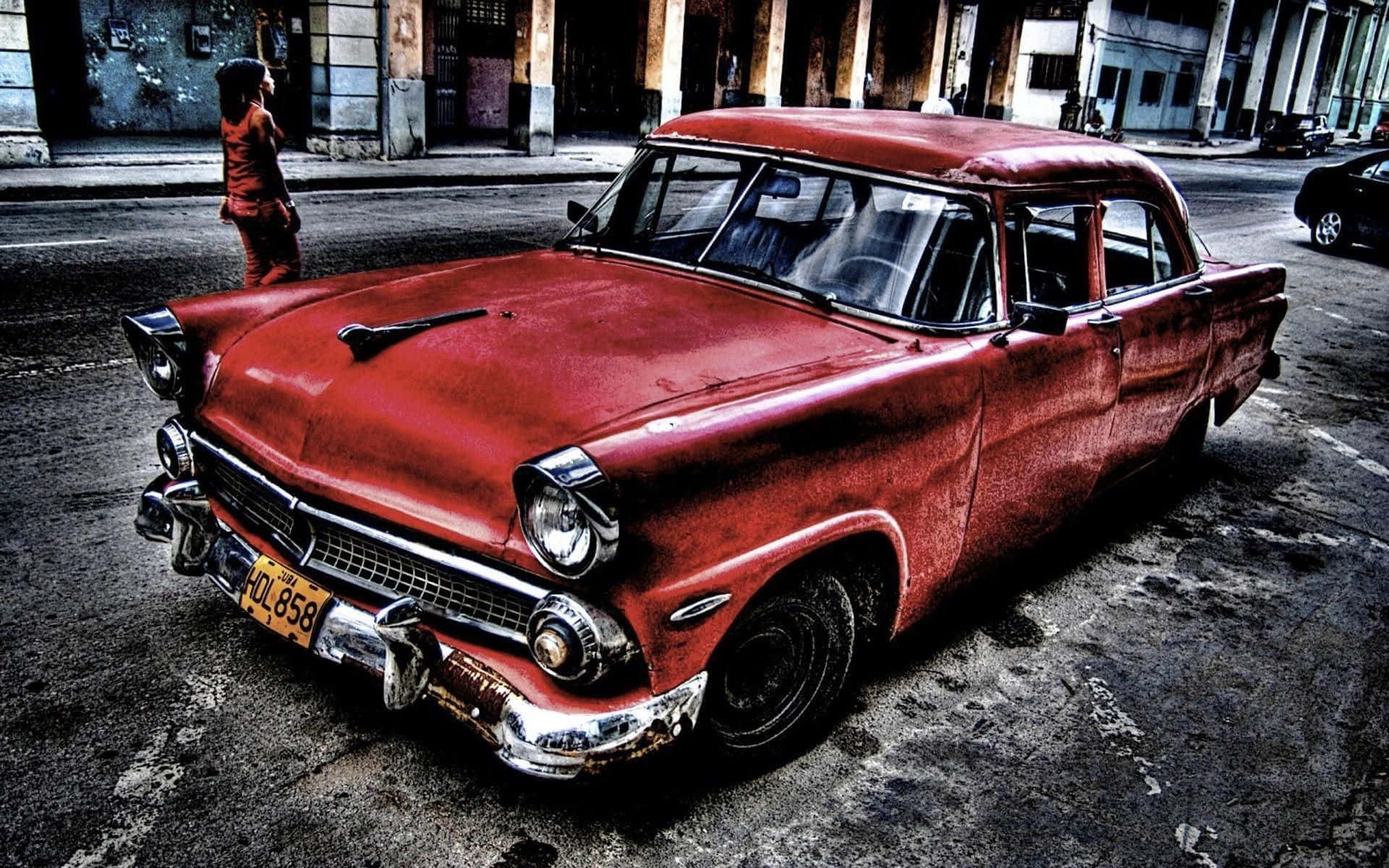 A Red Car Is Parked On The Street In Cuba Background