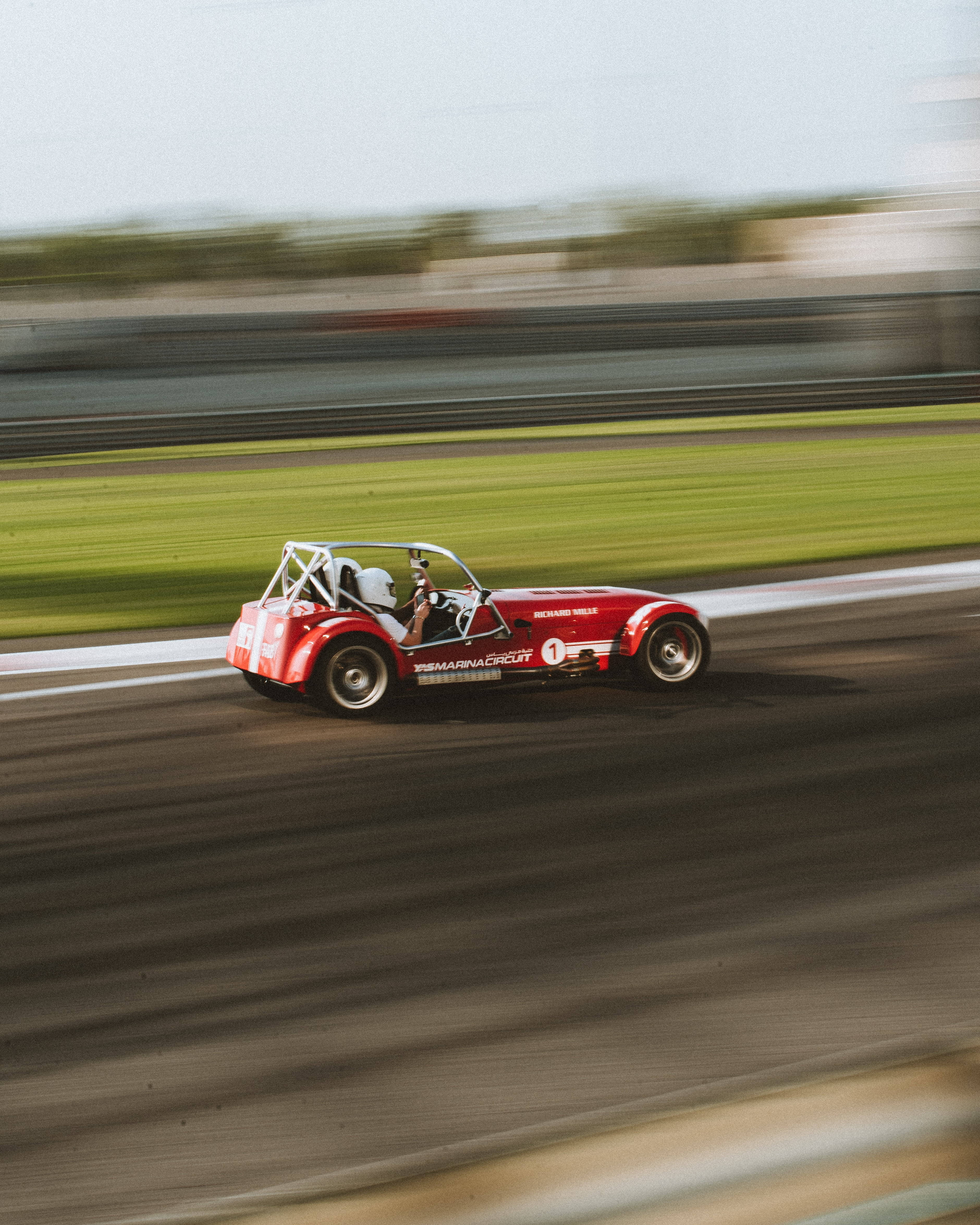 A Red Caterham Racecar At Maximum Speed Background