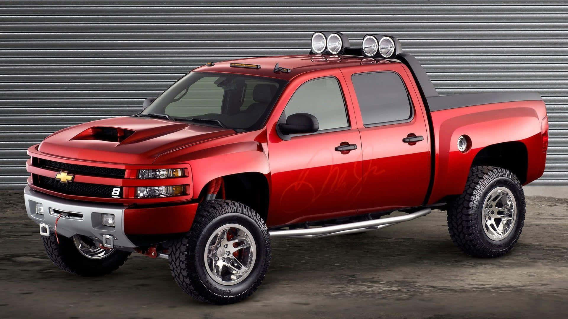 A Red Chevrolet Silverado Truck Is Parked In Front Of A Garage